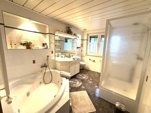 a bathroom with a tub and a shower and a sink at Ferienwohnung Am Blessberg in Stelzen in Eisfeld