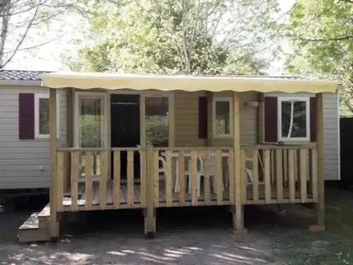 a screened in porch on a tiny house at ZEcamping 3 étoiles piscine chauffée toboggans pet friendly locatif TV 8 pers in Saucède