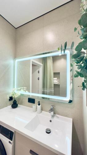 a bathroom sink with a large mirror above it at City Park Irpin - four in Irpin
