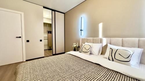 a bedroom with a large bed with white pillows at City Park Irpin - four in Irpin