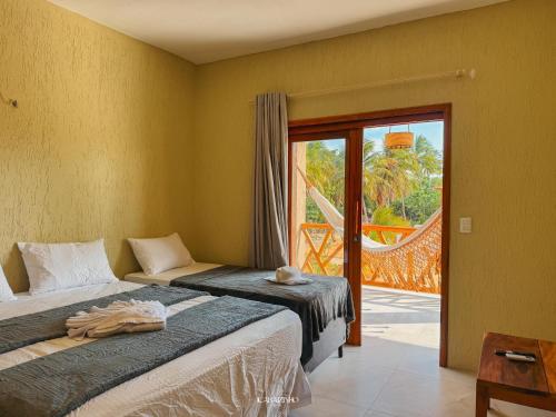 a bedroom with two beds and a sliding glass door at Icaraizinho House in Icaraí