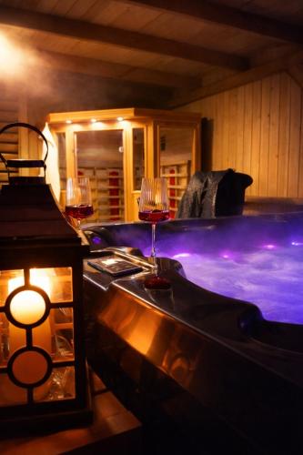 a hot tub with two glasses of wine at Domek u Anitki i Nikosia in Jeleśnia