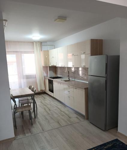 a kitchen with a stainless steel refrigerator and a table at Central Apartment Bacău in Bacău
