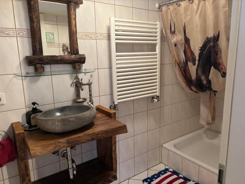 ein Badezimmer mit Waschbecken und einem Pferdebild an der Wand in der Unterkunft Western-Inn in Klipphausen