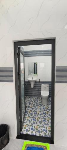a bathroom with a white toilet and a sink at Arasam Homestay Bình An in Ấp Thanh Sơn (1)