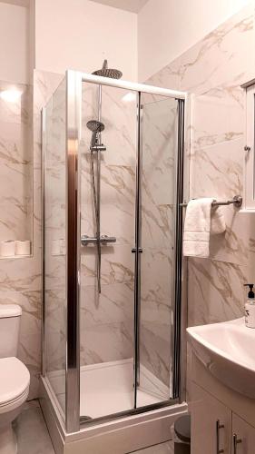 a bathroom with a shower and a toilet at United Lodge Hotel in London