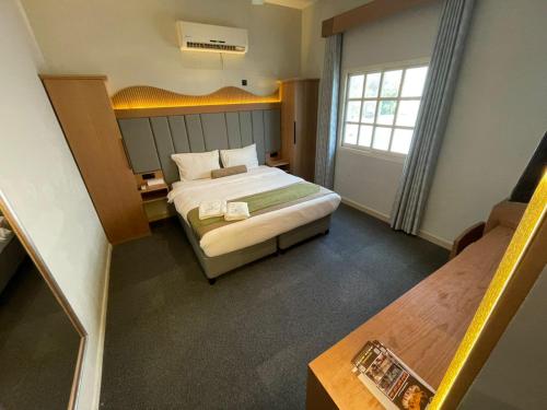 a hotel room with a bed and a window at Coral Bay Suite Hotel in Khor Fakkan
