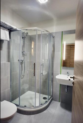 a bathroom with a shower with a toilet and a sink at GREEN HOTEL Ostrava in Jáma František