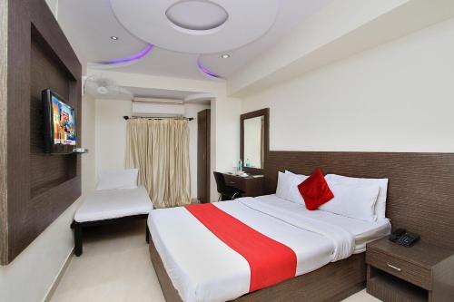 Habitación de hotel con cama grande y TV en Hotel MB International, en Mysore