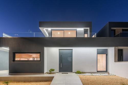 a contemporary house with a black and white facade at Dune House - Villa With Private Dune and Sea View in Viana do Castelo