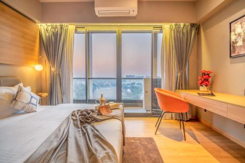 a bedroom with a bed and a desk and a window at The Vilton in Raipur