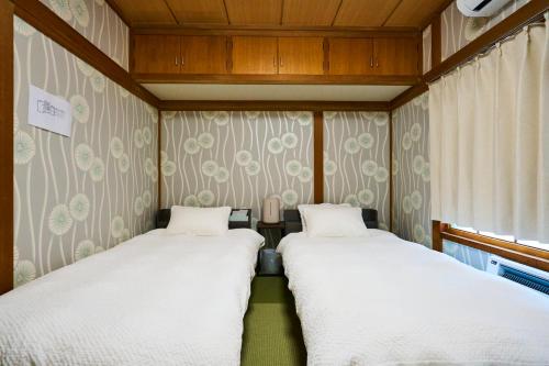 two beds in a small room with a window at Imari in Asahikawa