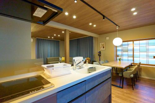 a kitchen with a sink and a dining room at Imari in Asahikawa