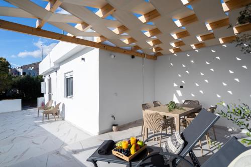 a patio with a wooden pergola and a table at Alea Villa in Ierapetra
