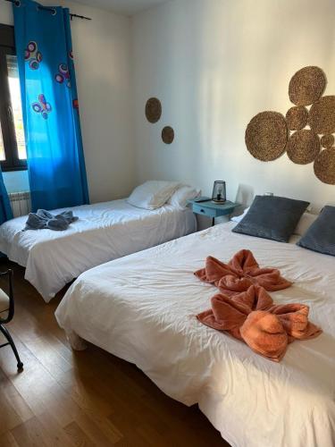 two beds with towels on them in a room at Casa Rural Aires de Mondalindo in Bustarviejo