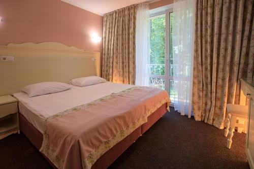 a bedroom with a bed and a large window at VitaPark Sonyachnyy Provans in Satanov