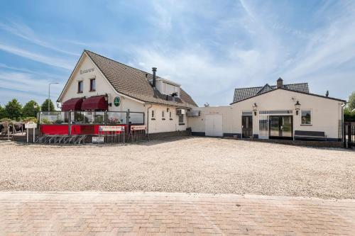 a large white building with a large parking lot at B&B De Betuwe Asch in Asch
