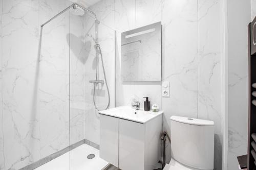 a white bathroom with a shower and a toilet at Sweet-patio in Briey