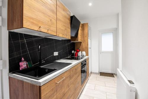 a kitchen with a sink and wooden cabinets at Sweet-patio in Briey