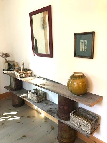 a table with a mirror and baskets on a wall at Shackmatack in Tenants Harbor