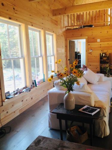 a living room with a couch and flowers on a table at Shackmatack in Tenants Harbor