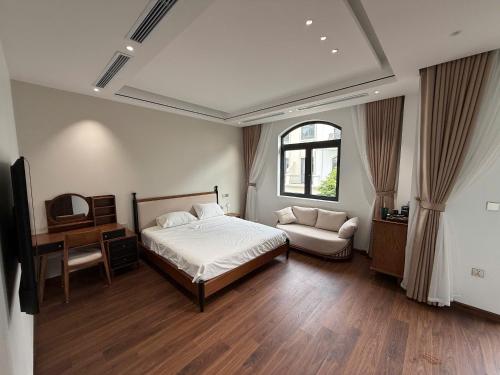 a bedroom with a bed and a chair and a window at MoonLight Homestay in Hòa Bình