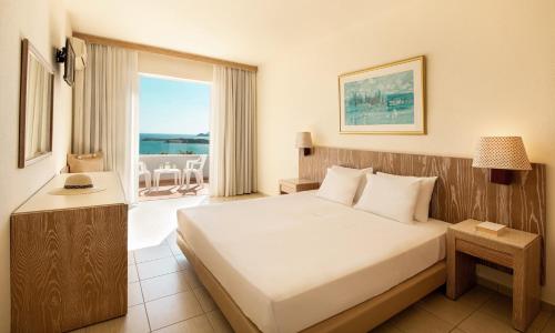 a hotel room with a bed and a balcony at Mitsis Bali Paradise in Bali