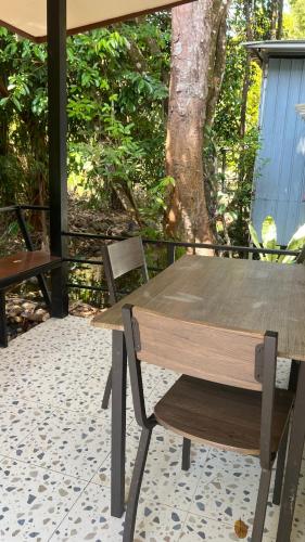 a wooden table and a chair on a patio at Similan Resort & Water Fall in Ban Lam Ru (1)