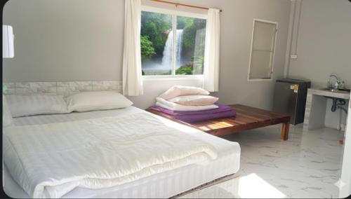 a bedroom with a bed and a window and a table at Similan Resort & Water Fall in Ban Lam Ru (1)