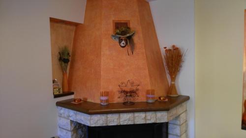 a room with a fireplace with a clock on the wall at Patriko in Áyios Nikólaos