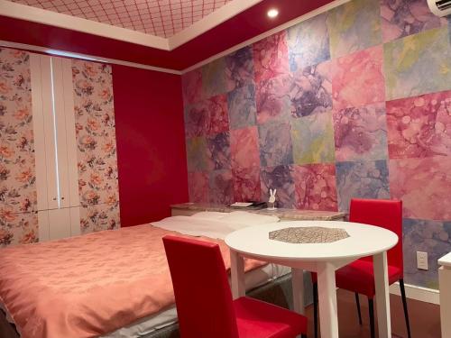 a room with a bed and a table and chairs at ホテルフローレスツー 燕三条 in Tsubame