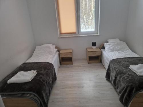 a room with two twin beds and a window at Gościniec nad Dobrzycą in Wałcz