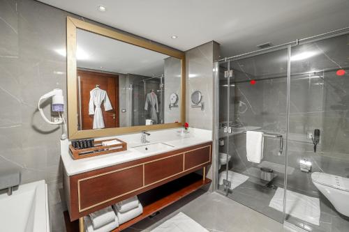 a bathroom with a sink and a shower and a mirror at Porto Said Hotel & Spa in Port Said