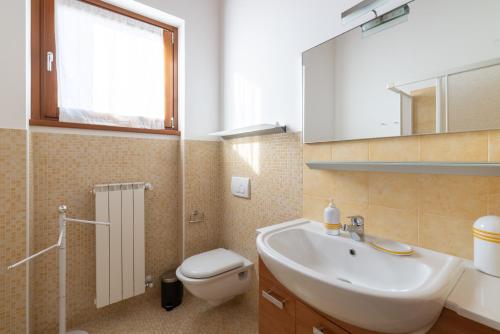 a bathroom with a sink and a toilet and a mirror at Hostdomus - Villa Bea free garage and pool in Magliolo