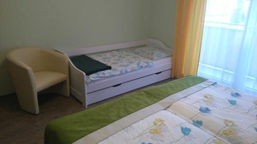 a small bedroom with a bed and a chair at Gasthof zum Mohrn in Oberwölz Stadt
