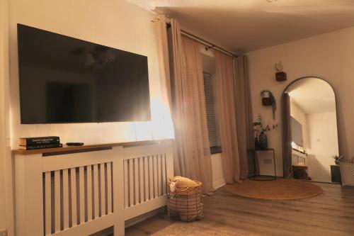 a living room with a large flat screen tv on the wall at Cosy Chester Casa - free parking in Chester