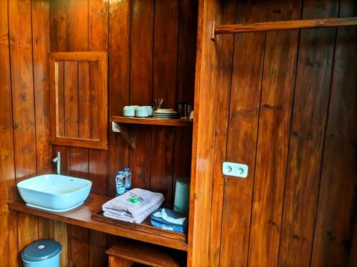 a bathroom with a sink and a wooden wall at Pineforrest in Sukapura