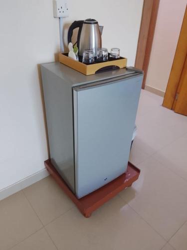 a small refrigerator with a tea kettle on top of it at Coral Bay 1 Bedroom apartment
