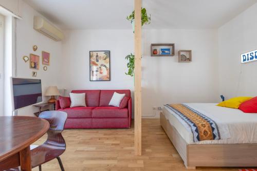 a bedroom with a bed and a red couch at Bindarella ai Navigli in Milan