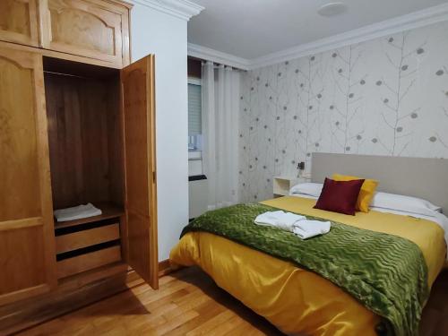 a bedroom with a bed with two towels on it at Apartamentos Shalom Ribadeo in Ribadeo