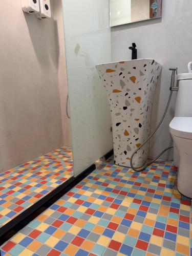 a bathroom with a toilet and a colorful tiled floor at Fei Li Jin Hotel in Kenting