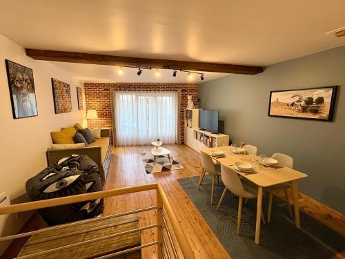 ein Wohnzimmer mit einem Tisch und ein Esszimmer in der Unterkunft O'Balcon in Sainghin-en-Mélantois