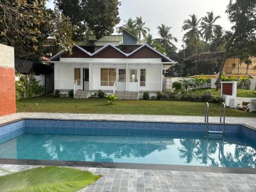 a house with a swimming pool in front of a house at Aagneyam villa in Kozhikode