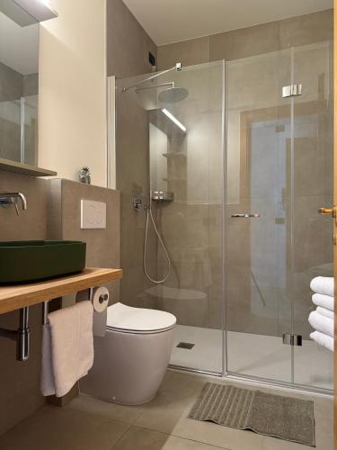 a bathroom with a shower with a toilet and a sink at Casa Merano Residence & Restaurant Bibione - New suites in Bibione