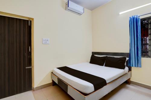 a bedroom with a bed in a room at Hotel O Bluestar in Bangalore
