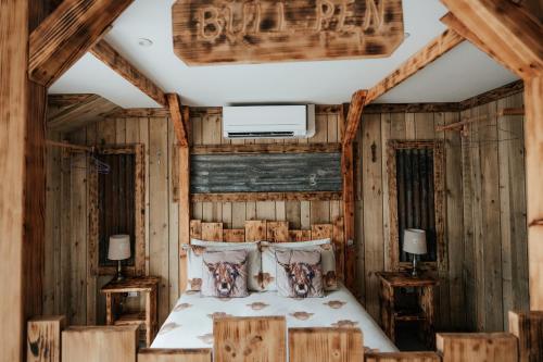 a bedroom in a log cabin with a bed at The Moo-tel at Moody Meadows in Aberaeron