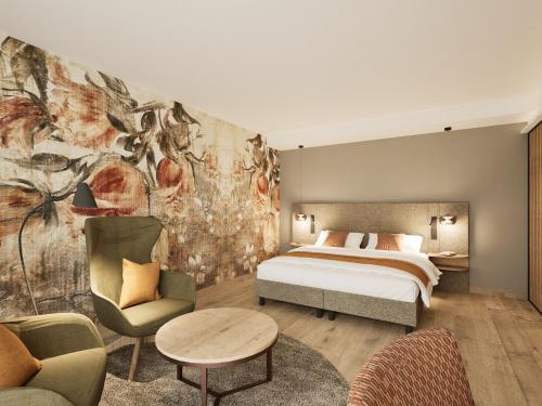 a bedroom with a bed and a couch and chairs at Churfürstenhof Wellnesshotel in Bad Birnbach