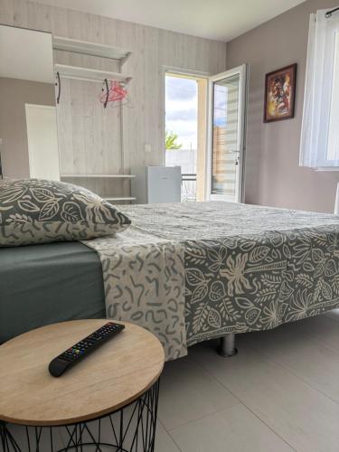 a bedroom with a bed and a remote control on a table at Suite indépendante avec piscine proche Océan in Saint-Vincent-de-Tyrosse