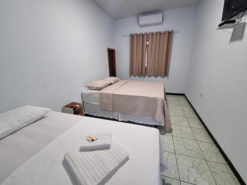 a room with two beds and a table in it at Quartus Hotel in Água Boa