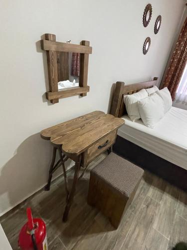 a bedroom with a wooden table next to a bed at Kıymet Aydogdu in Alaçatı
